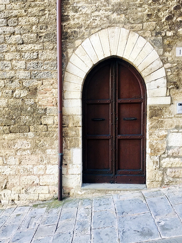 Porta medievale in legno scuro, lungo la salita per Piazza Grande a Gubbio