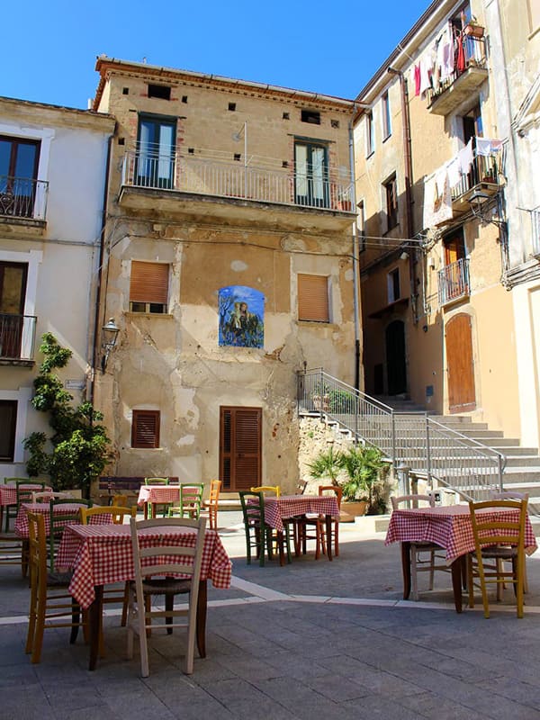 paese di pisciotta: piazzetta Michelangelo Pagano con le sedie colorete e i tavoli con tovagliette da osteria